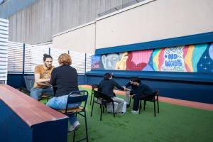 un gruppo di persone seduti su sedie in una stanza di Ideal Youth Hostel a Barcellona