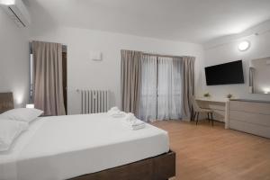 una camera da letto bianca con un letto bianco e una scrivania di B&B Le Stanze del Duomo a Firenze Altre 197 foto