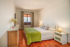 a bedroom with a white bed with a green blanket at CHL Serycam Breña Baja, infinity views in Breña Baja