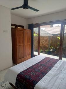 a bedroom with a bed and a large window at Rumah Ramah Ubud in Ubud