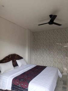 a bedroom with a bed with a ceiling fan at Rumah Ramah Ubud in Ubud