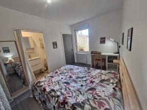 een slaapkamer met een bed, een bureau en een raam bij Appartement F2 5A in Martres-de-Veyre