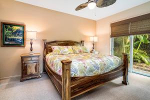 een slaapkamer met een houten bed en een raam bij KaMilo Villa Heated Pool Golf Course Views Beach Club Access in Waikoloa +46 foto's