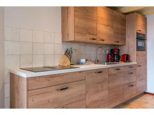a kitchen with wooden cabinets and a sink at Lovely Holiday Home in Texel near Sea in Oost