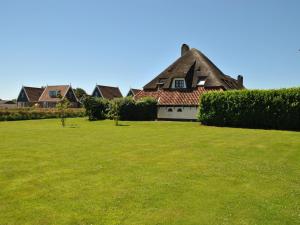 a house with a grassy yard in front of it at Lovely Holiday Home in Texel near Sea in Oost