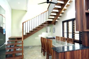 een keuken met een houten trap en een tafel met stoelen bij PATHIRAMANAL Service Villas in Alleppey +3 foto's
