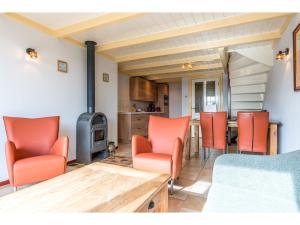 a living room with orange chairs and a wooden table at Lovely Holiday Home in Texel near Sea in Oost