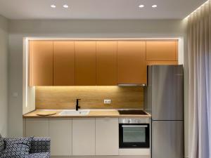 a kitchen with white cabinets and a stainless steel refrigerator at Venice Studios & Apartments in Stavros