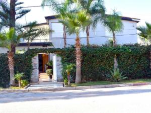 a house with palm trees in front of it at Villa Les Ambassades in Kenitra