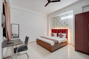 a bedroom with a bed and a table and a desk at FabHotel Tree view Residency in Lucknow +19 photos