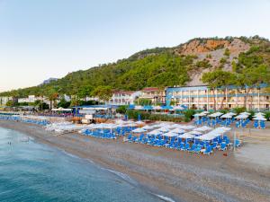 a beach with chairs and umbrellas and a hotel at Club Hotel Rama in Beldibi
