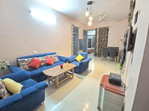 a living room with blue couches and a table at Vishwanathan in Varanasi