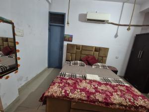 a bedroom with a bed with a red blanket on it at Vishwanathan in Varanasi