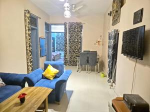 a living room with blue couches and a table at Vishwanathan in Varanasi +8 photos