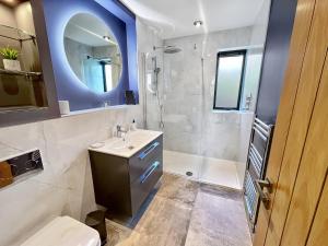 een badkamer met wastafel en douche met spiegel bij The Chapel Brompton Regis in Brompton Regis +35 foto's