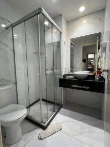 een badkamer met een douche, een toilet en een wastafel bij Ponta Negra Beach Melo Flat in Natal