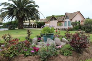 un jardín frente a una casa con flores en Apart Hotel Y Cabanas Vegasur en La Serena