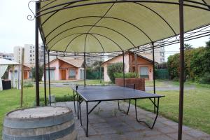 uma mesa de pingue-pongue debaixo de uma tenda com um barril em Apart Hotel Y Cabanas Vegasur em La Serena