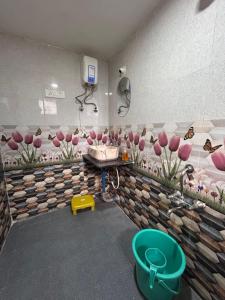 een badkamer met roze bloemen aan de muur bij Gajalee Beach House in Bhogwe