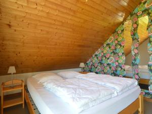 een bed in een kamer met een houten plafond bij Family Home in Sourbrodt in Sourbrodt