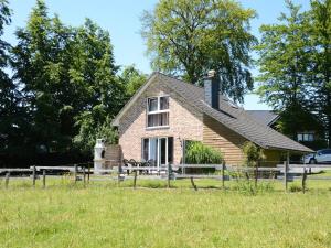een bakstenen huis met een hek in een veld bij Family Home in Sourbrodt in Sourbrodt