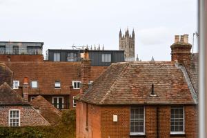 a view of roofs of buildings with a clock tower at Cathedral Cottage in Canterbury