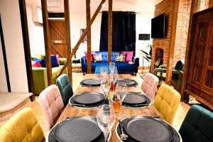 a wooden table with plates and wine glasses at Cathedral Cottage in Canterbury
