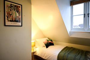 a bedroom with a bed and a window at Cathedral Cottage in Canterbury
