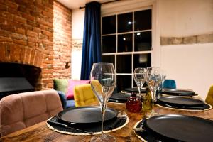 a wooden table with wine glasses on top of it at Cathedral Cottage in Canterbury