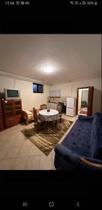 a living room with a table and a couch and a kitchen at Lily in Sremska Kamenica