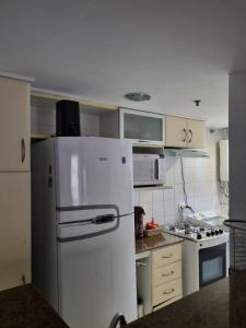 a kitchen with a white refrigerator and a stove at Best Residence in Rio de Janeiro