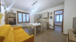 ein Wohnzimmer mit einem gelben Sofa und einem Tisch in der Unterkunft Hostdomus - Chez Paul in Cesana Torinese + 5 Fotos