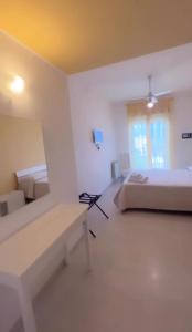 a white room with two beds and a bench at Aurea Suites in Palermo +2 photos