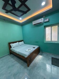 une chambre avec un lit dans une pièce verte dans l'établissement Vacational Home Stay, à Rameswaram