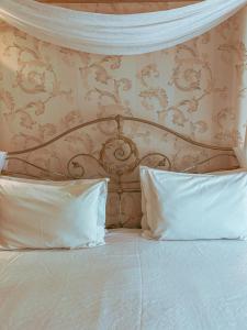 a bed with two pillows in front of a wall at Pousada Ares da Serra - Centro in Gramado +74 photos