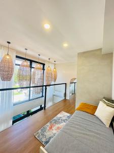 a bedroom with a bed and a balcony with windows at Saffron Villa in Pampang