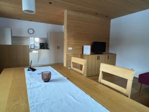 a room with a large wooden table and a kitchen at Appartements Birkenhof in Lech am Arlberg +16 photos