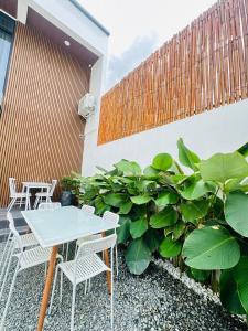 a table and chairs on a patio with plants at Saffron Villa in Pampang
