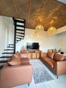 a living room with a couch and a flat screen tv at Saffron Villa in Pampang