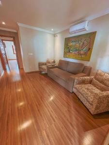 a living room with a couch and two chairs at Pousada Ares da Serra - Centro in Gramado