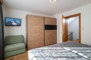 a bedroom with a bed and a chair at Chalet Veronika in Fieberbrunn