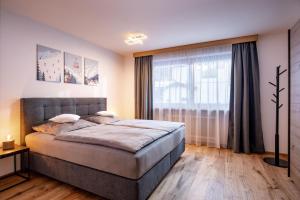 a bedroom with a bed and a large window at Chalet Veronika in Fieberbrunn