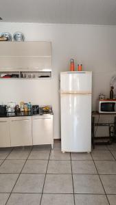 a kitchen with white cabinets and a white refrigerator at Casa - BC in Balneário Camboriú