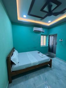 une chambre avec un lit dans une pièce bleue dans l'établissement Vacational Home Stay, à Rameswaram