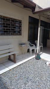 a patio with a bench and a table and chairs at Casa - BC in Balneário Camboriú