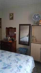 a bedroom with a bed and a mirror and a dresser at Casa - BC in Balneário Camboriú