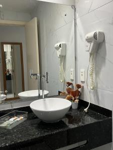 een badkamer met een wastafel en een spiegel bij Ponta Negra Beach Melo Flat in Natal