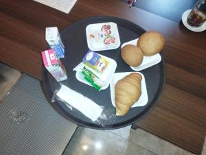 Ein Teller mit Essen, Brot und Brötchen auf einem Tisch in der Unterkunft ALRashedy Hotel Powered by Boutique in Kairo