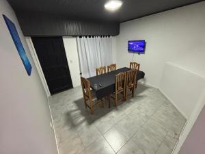 ein Esszimmer mit Tisch und Stühlen und einem Fernseher in der Unterkunft Casa necochea in Necochea
