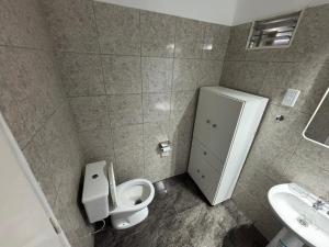 ein Badezimmer mit Toilette und Waschbecken in der Unterkunft Casa necochea in Necochea + 10 Fotos